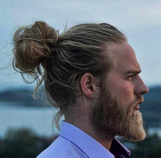 A-photograph-of-a-hipster-male-with-the-perfect-man-bun-hairstyle-placed-on-the-vertex-area-of-his-head-and-styled-with-long-wavy-hair